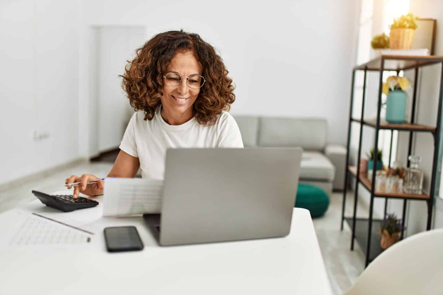 Middle age hispanic woman smiling confident working at home