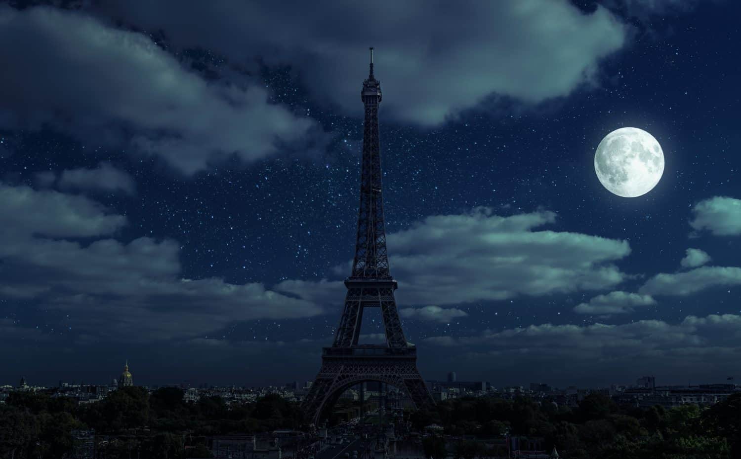 Paris at night during energy crisis, France. Full blackout of city due to expensive gas and electricity in Europe. View of Eiffel Tower and moon on dark sky. Concept of EU economy, sanctions, saving.