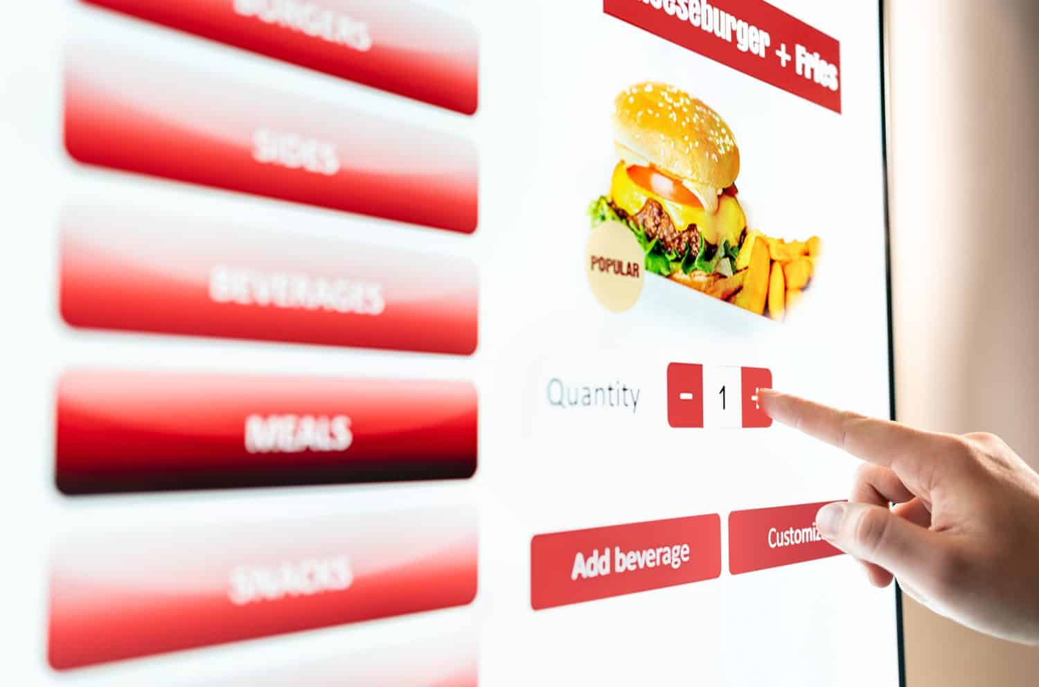 Self service order kiosk and digital menu in fast food burger restaurant. Touch screen in vending machine. Man using electronic selfservice technology and buying meal and paying.