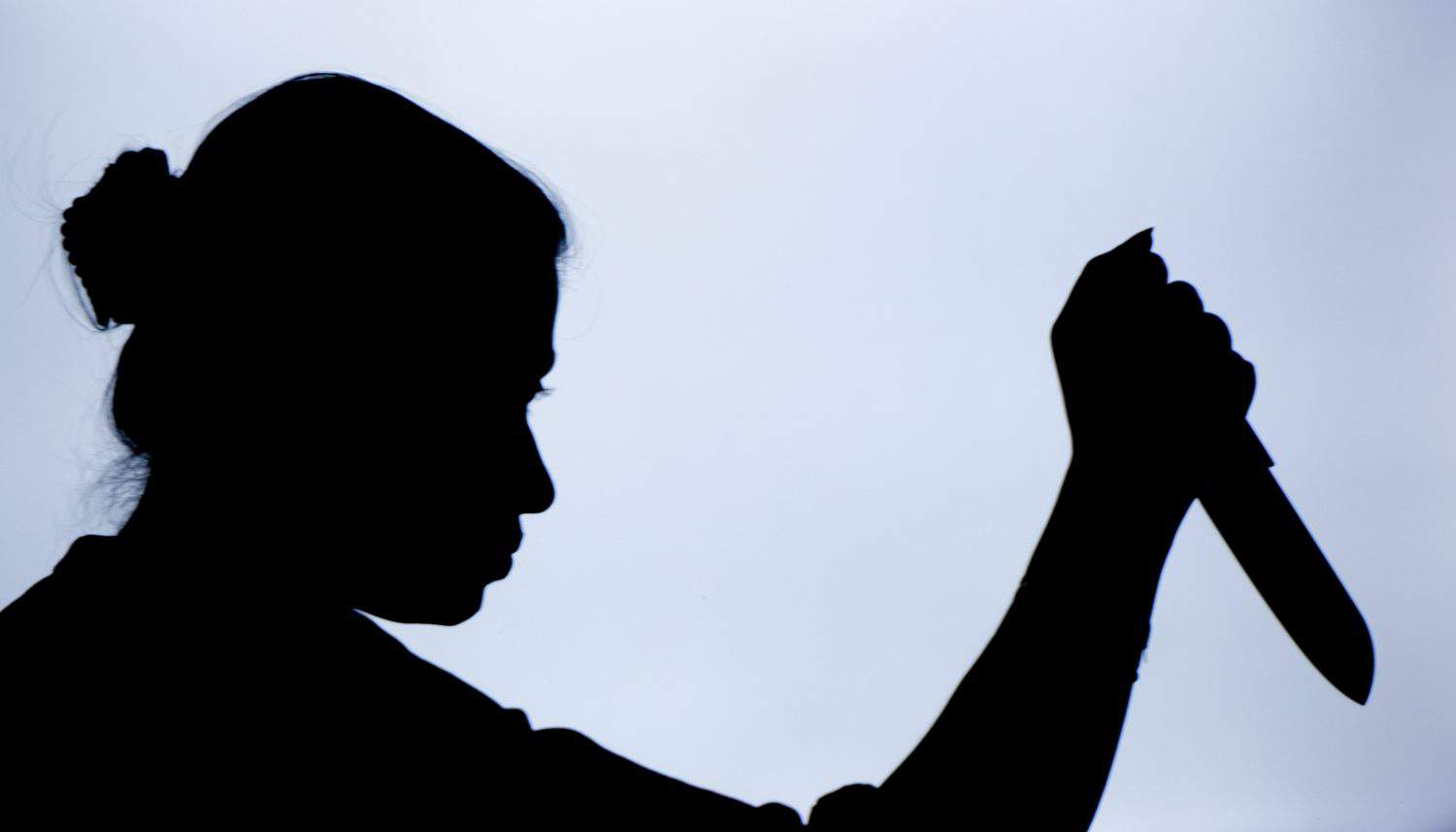 Shadow of a woman with knife in hand with suspicious activity or going to stab someone to death.