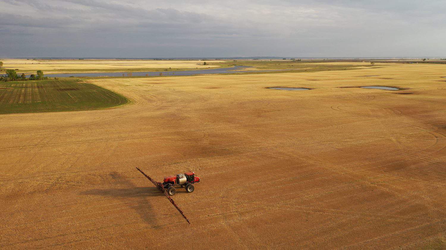 Aerial view of farmland in North Dakota, USA. American countryside, farming vehicles in the field