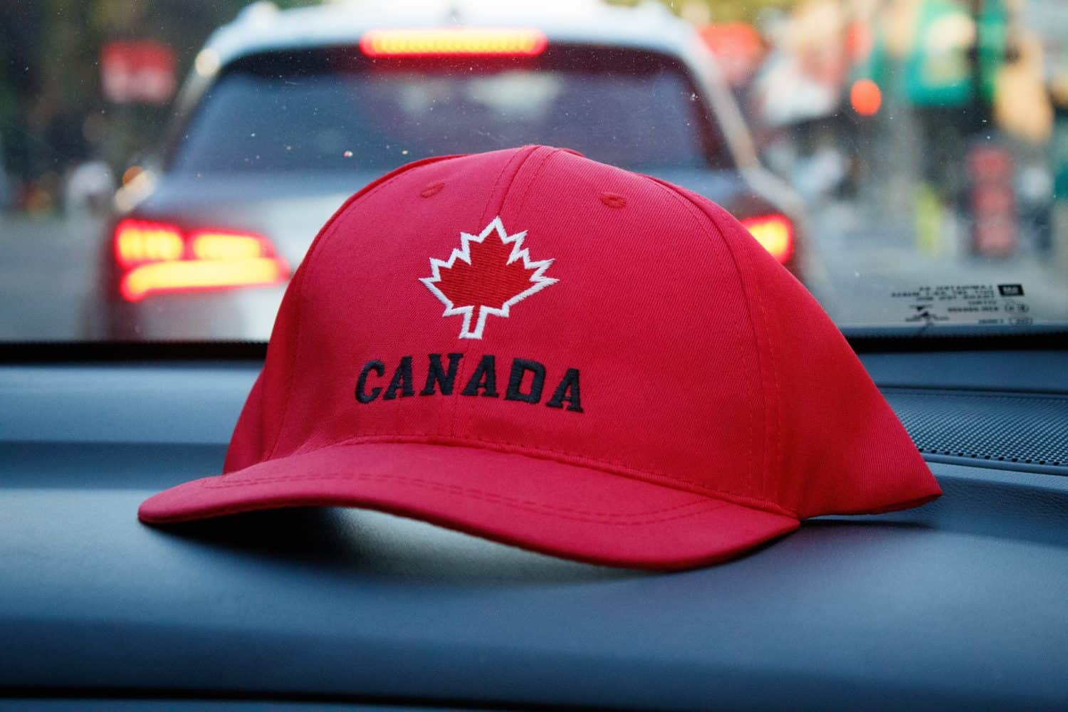 A Canadian baseball cap on a car dashboard 2