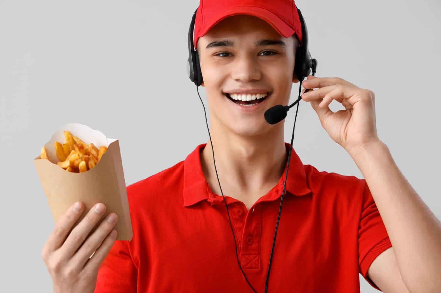 Male worker with french fries on light background, closeup