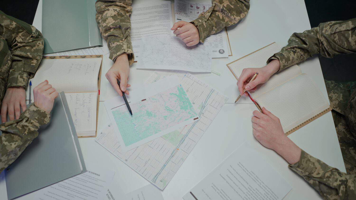 Group of security squad in control center. Military headquarters surveillance officers cyber police briefing at the table in office, close up shot.