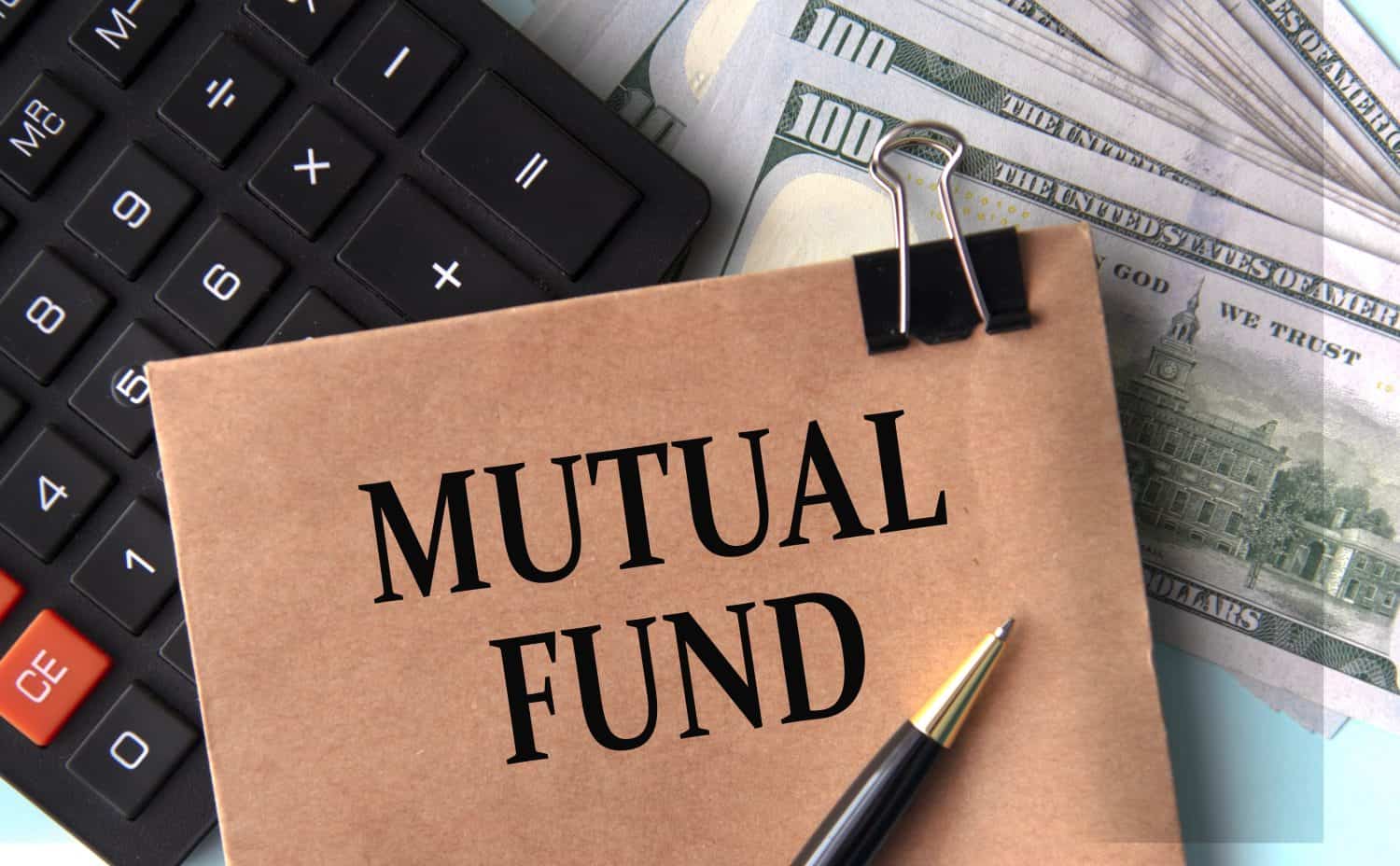 MUTUAL FUND - words on brown paper on the background of calculator and banknotes. Business concept