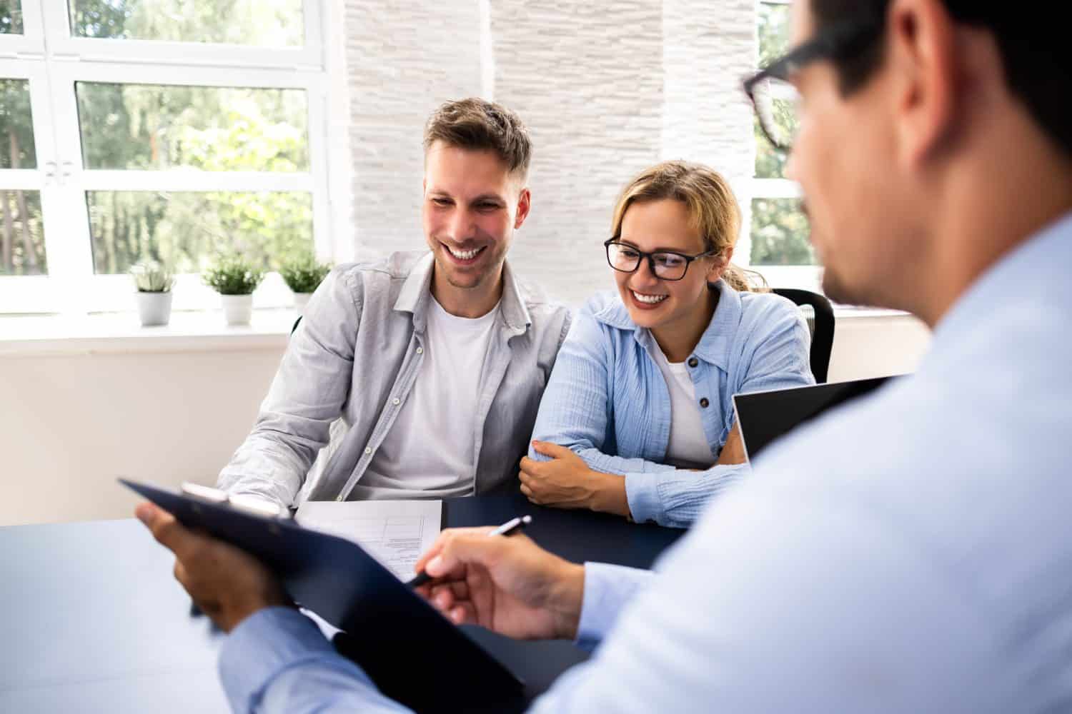 Financial consultant explaining new project investment to young couple in office. Real estate agent discussing mortgage options with family. Mortgage loan consultation with financial advisor.