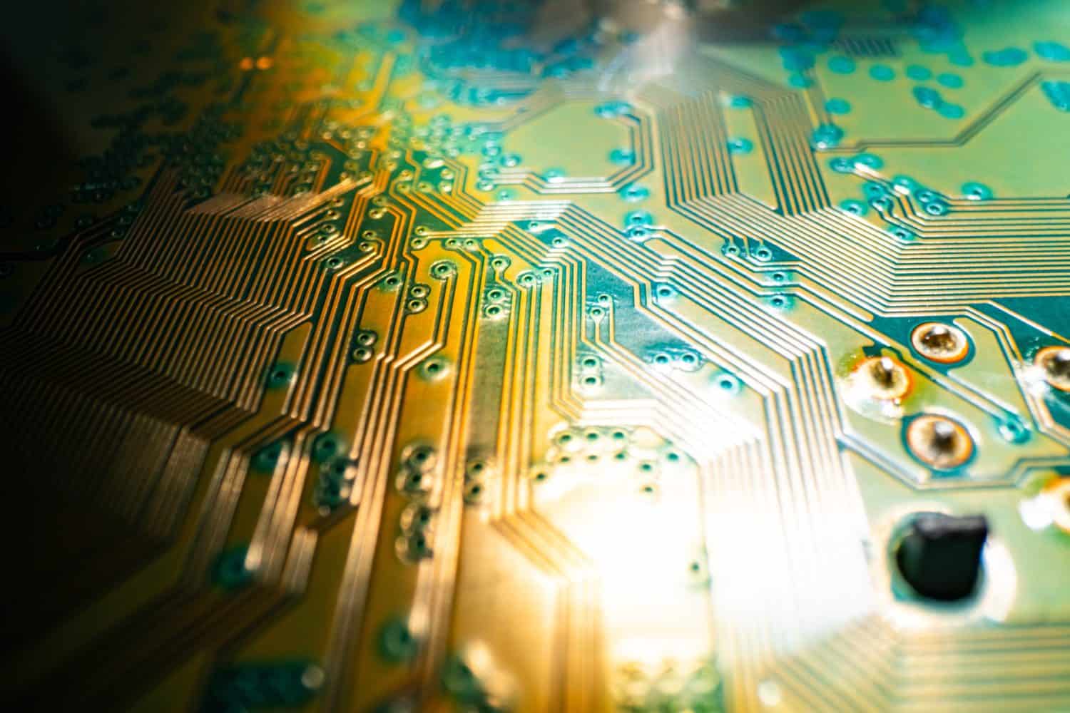 Electronic circuit board with semiconductors chip. Electronic motherboard card. Circuitry and close-up on electronics. Background of electronics on board electrical circuits, technology texture.