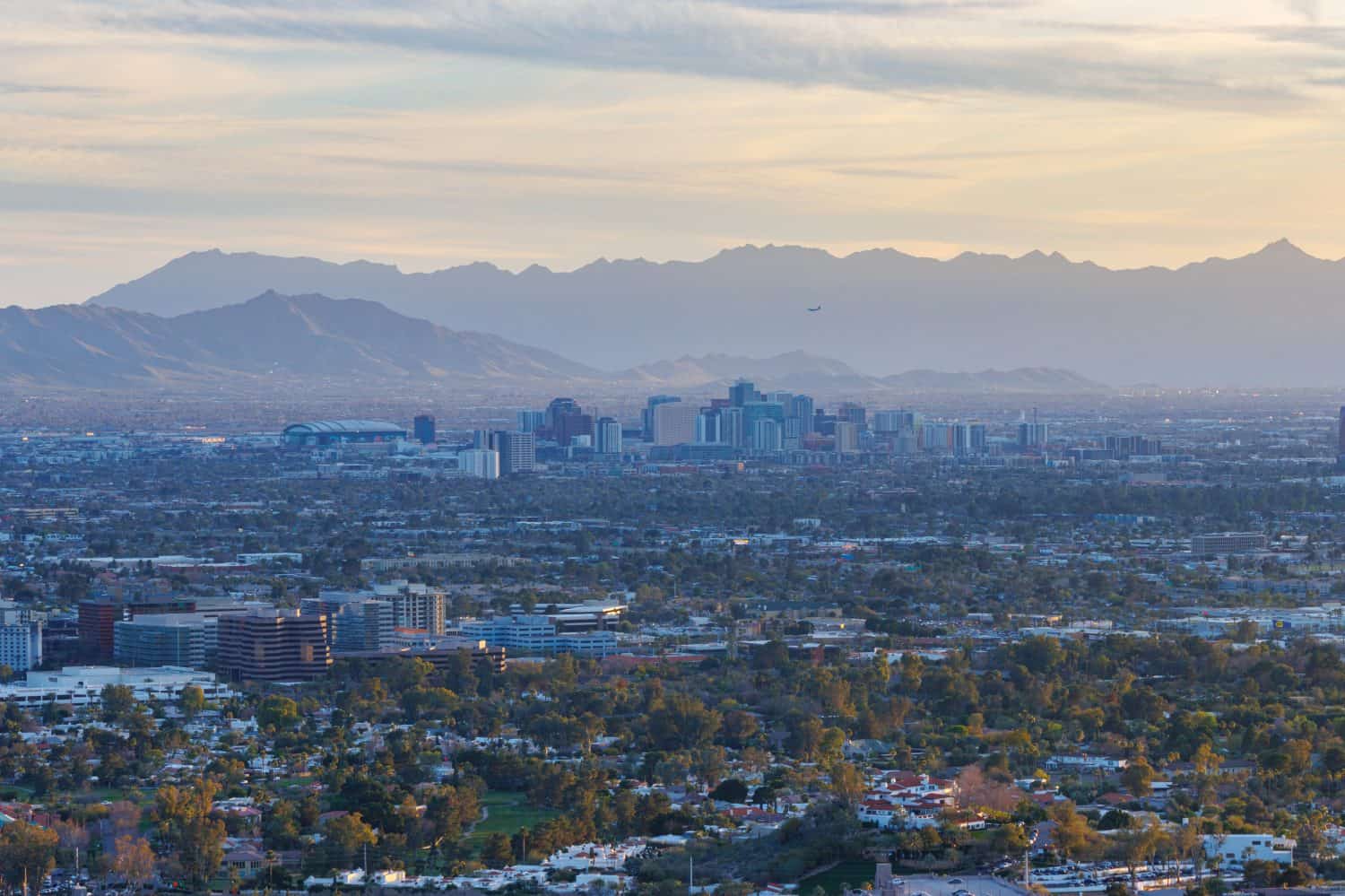 The Phoenix, Arizona skyline during the Sunset with an airplane flying to Skyharbor Airport