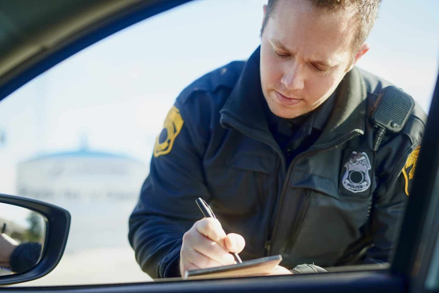 Writing, policeman and traffic stop with ticket for checkpoint, security and crime investigation on highway. Officer, law and driver registration for car accident, dui or road safety with suspect