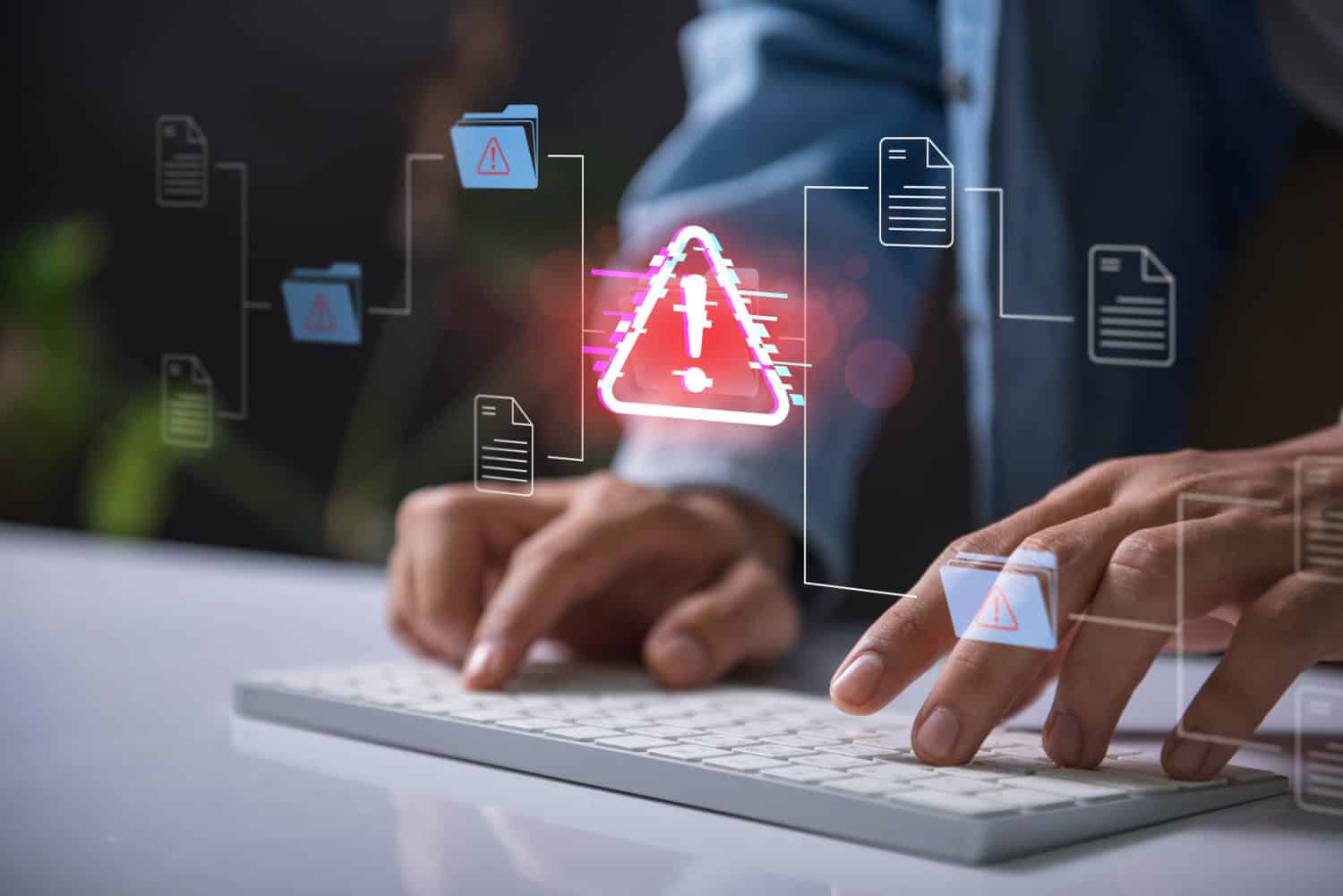 Warning alert icon with a hacked document system.Hands typing on a keyboard with a red cybersecurity threat alert, surrounded by digital files and documents.