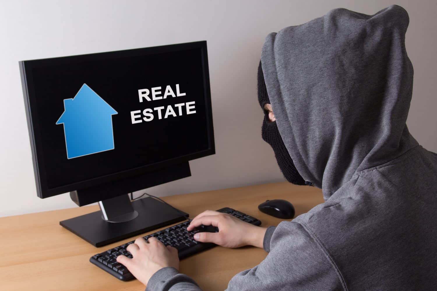 criminal and burglary concept - thief in mask searching info about real estate in internet