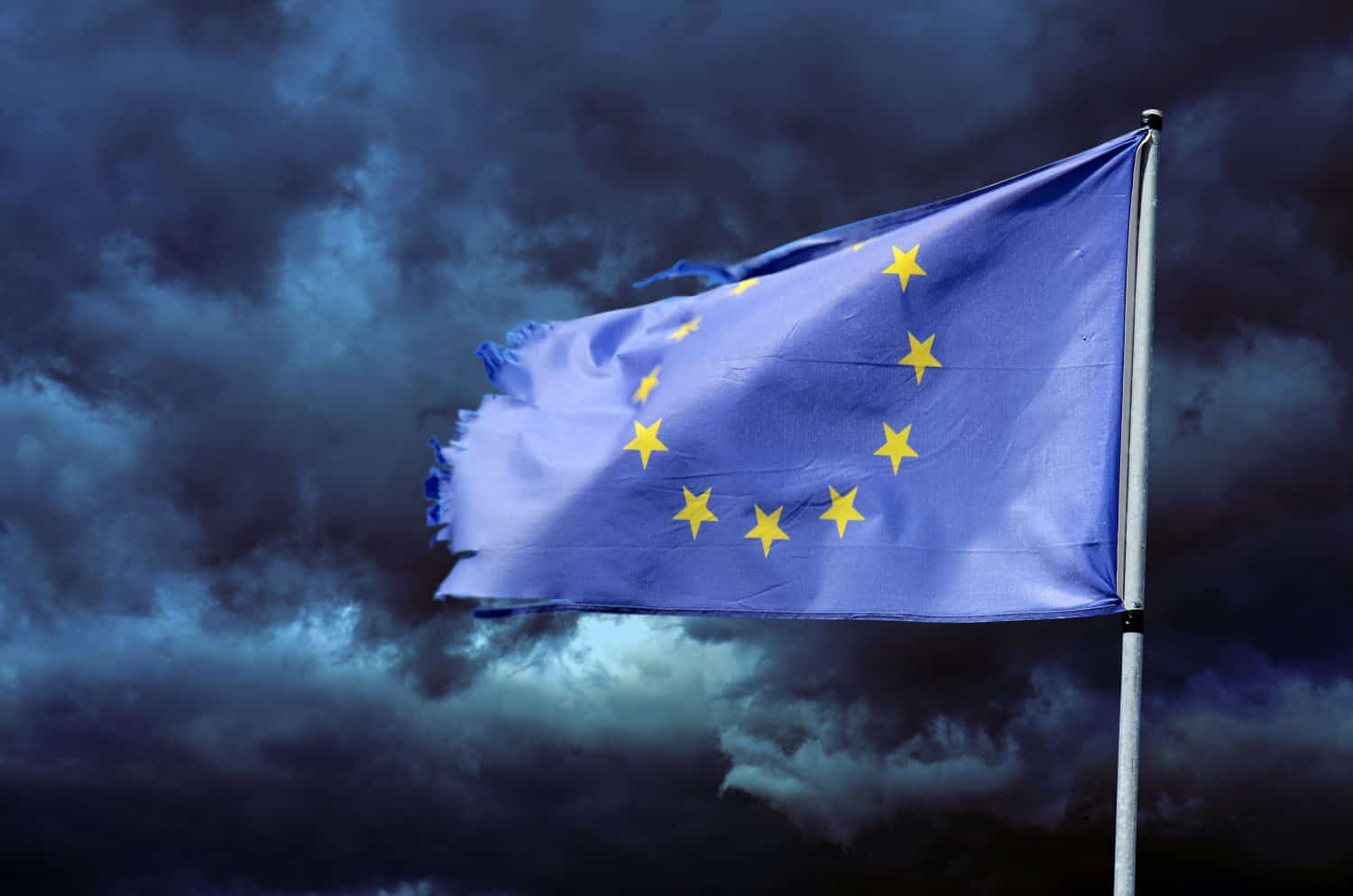 EU torn flag in stormy sky