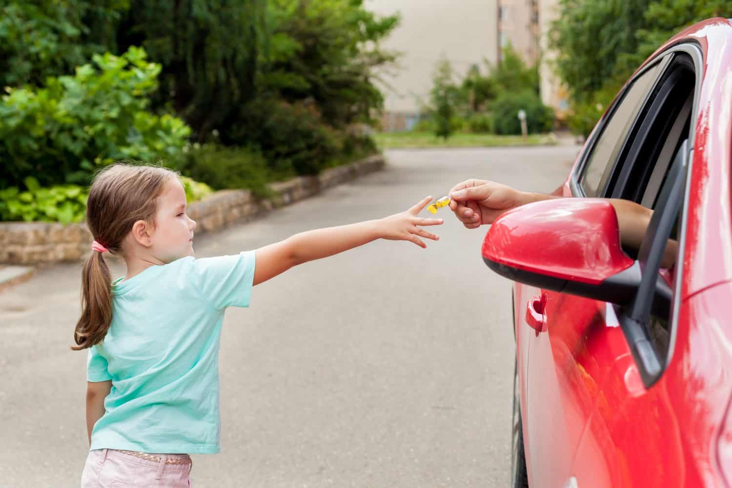 Stranger in the car offers candy to the child. Kids in danger. Children safety protection. Children kidnapping concept.