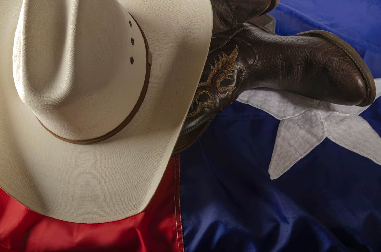 cowboy boots and hat on Texas flag