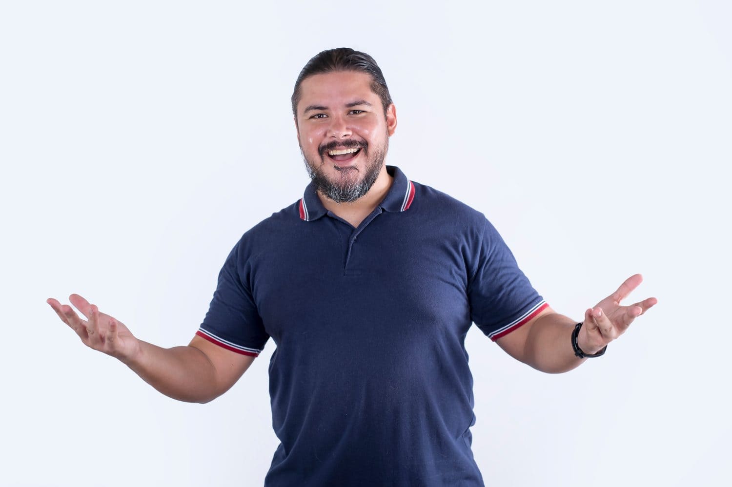 A friendly and joyful man waves his hands around while having a light fun discussion. Wearing a blue polo shirt. Isolated on a white background.