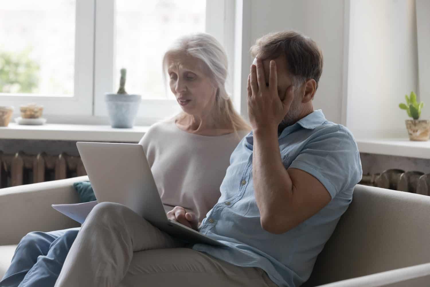 Frustrated stressed senior couple paying expensive bills, taxes, insurance fees online, discussing budget problems, too high expenses, money spending, bad news, scam, using laptop