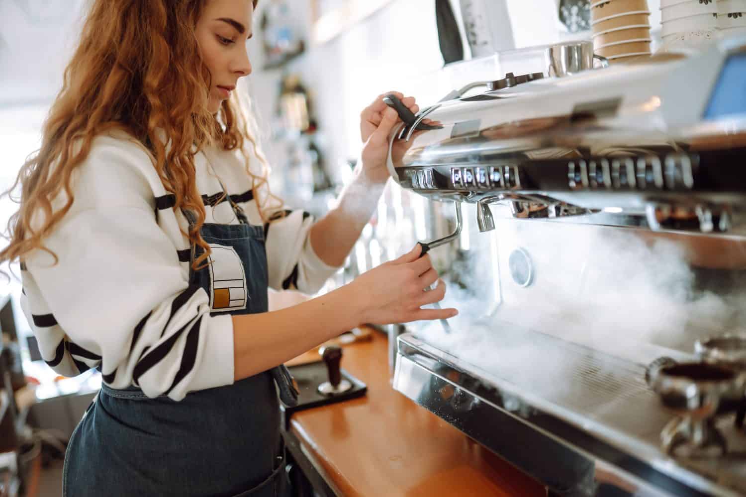 Female barista making coffee in coffee shop counter. Takeaway food.