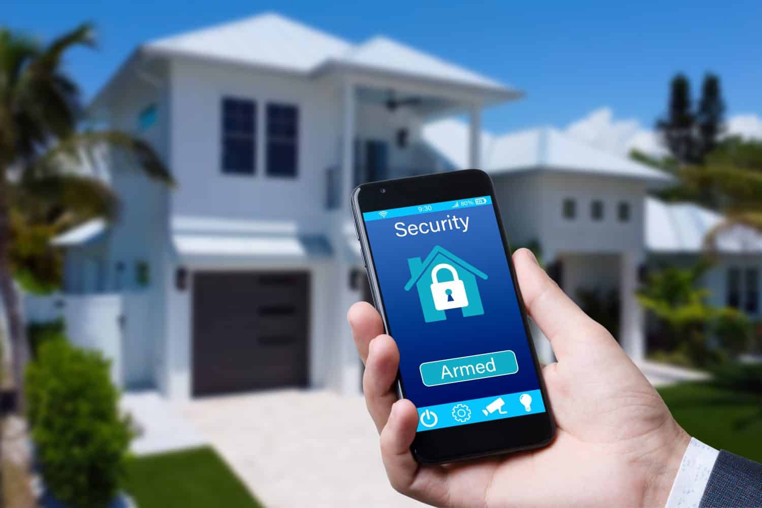 Smartphone with home security app in a hand on the building background