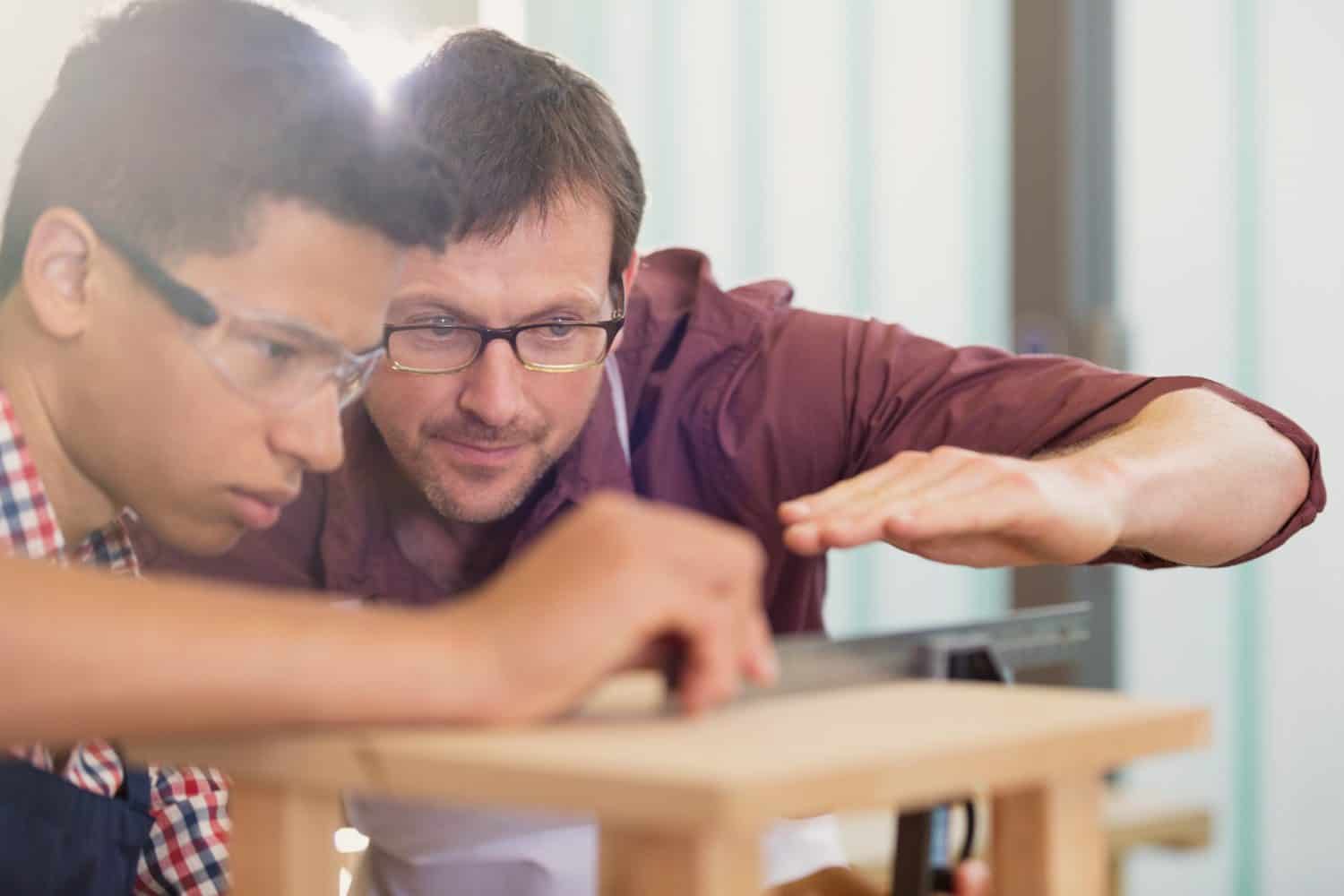 Carpentry teacher and student examining measurement