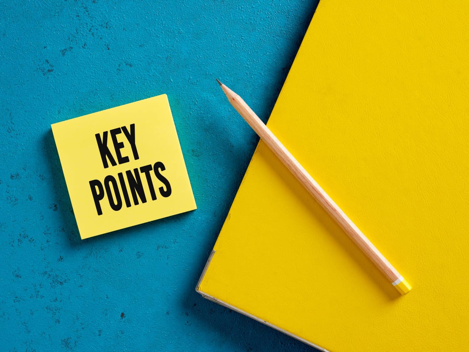The word key points on yellow sticky note paper with a pencil and binder. The key points of an issue in business or education.