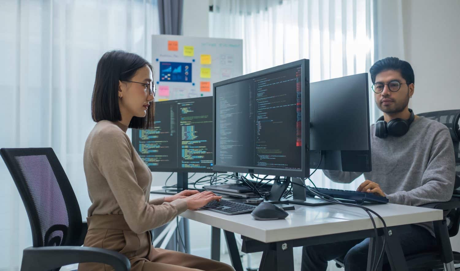 asian woman and Indian man Developer team working about programming software data online at office