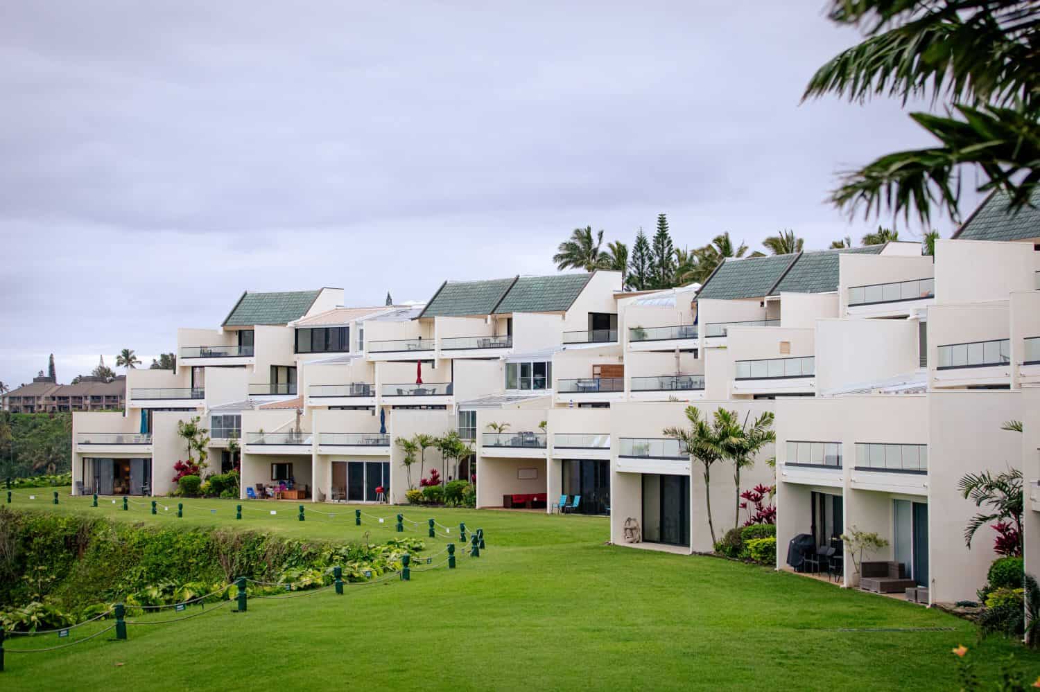 Vacation condo rental building in Princeville, with balconies facing the ocean, surrounded by palms and manicured lawa, north shore of Kauai, Hawaii