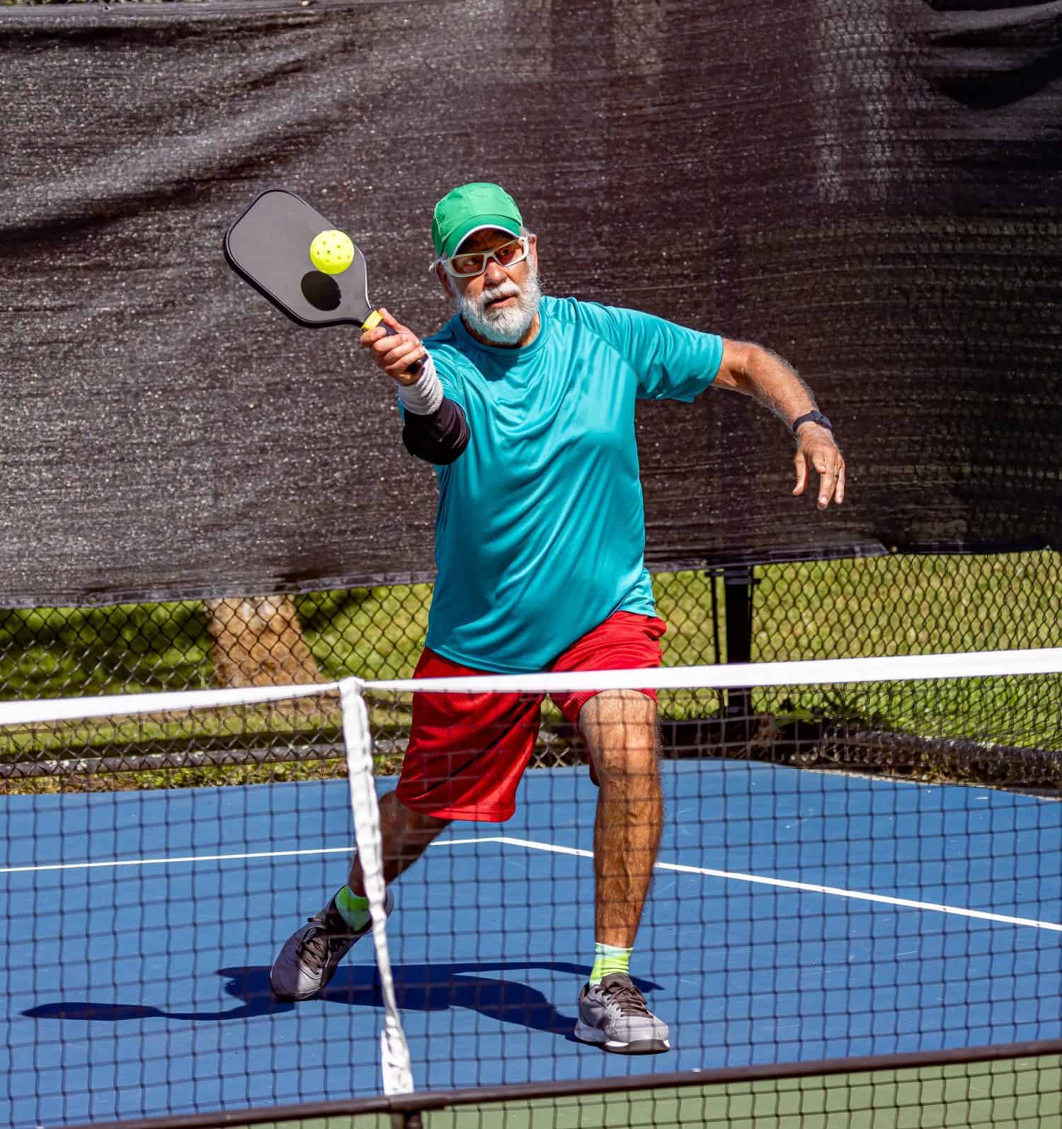 Pickleball player leans in to strike a sharp volley