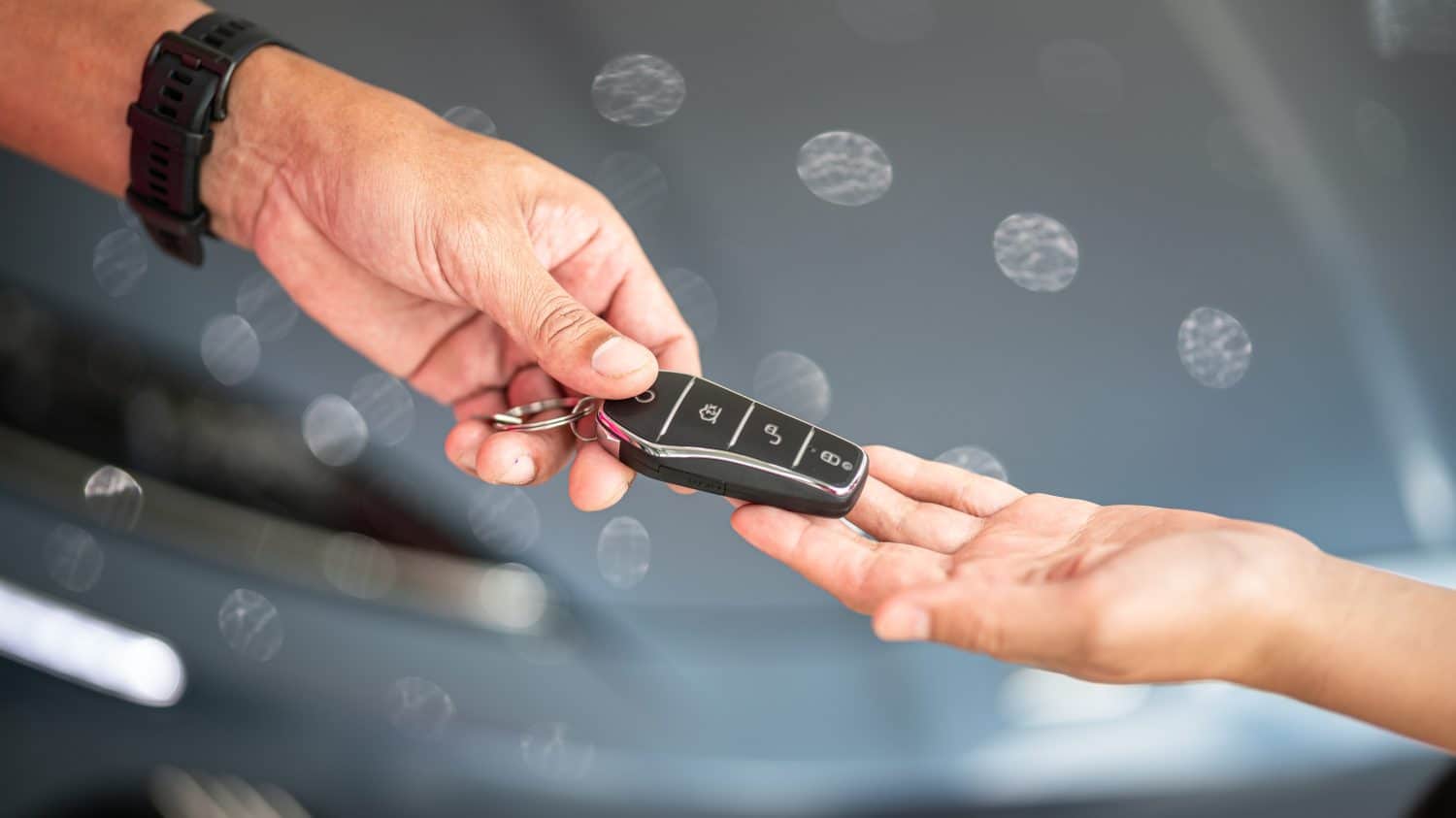 Action of human hands are giving and taking a car key. Buying the new car or car rental business concept scene, Close-up and selective focus at the object.