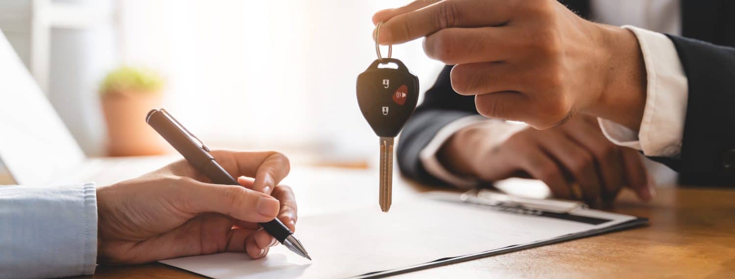 Business car rental company service, Close up hand of agent dealer giving, holding car key to customer renter, new owner after signed rental, purchase contract in document, vehicle sales agreement.