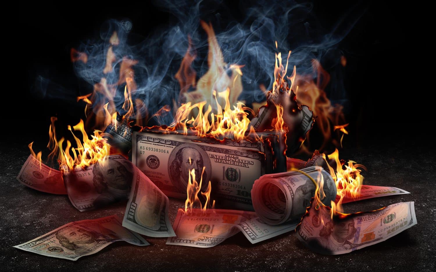 Burning money on black background. Financial crisis