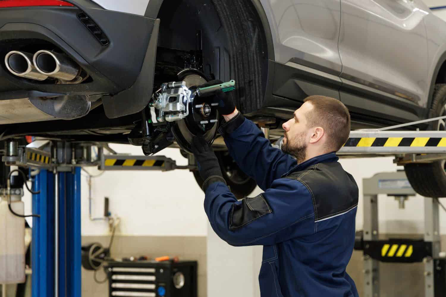 Brake pad repair, car on a lift, close-up. A modern car in a car service on a lift with a wheel removed. Elements of the brake system and suspension