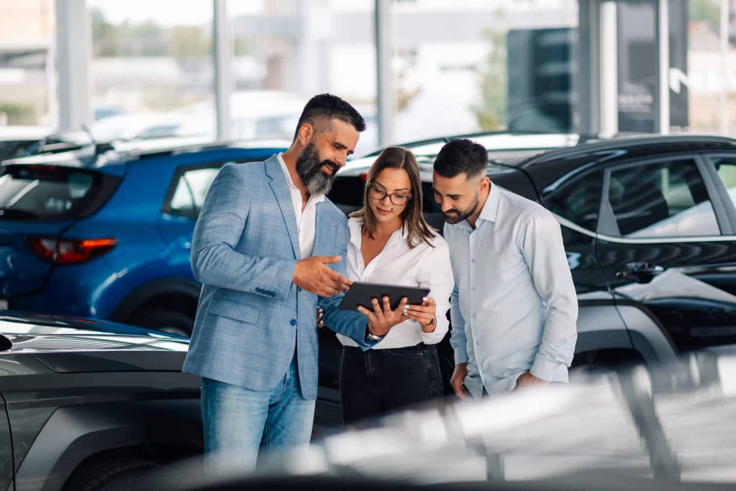 Dynamic interaction showcasing a car dealership&#039;s effective communication and sales skills in promoting vehicle features to potential clients in a bright and inviting showroom.