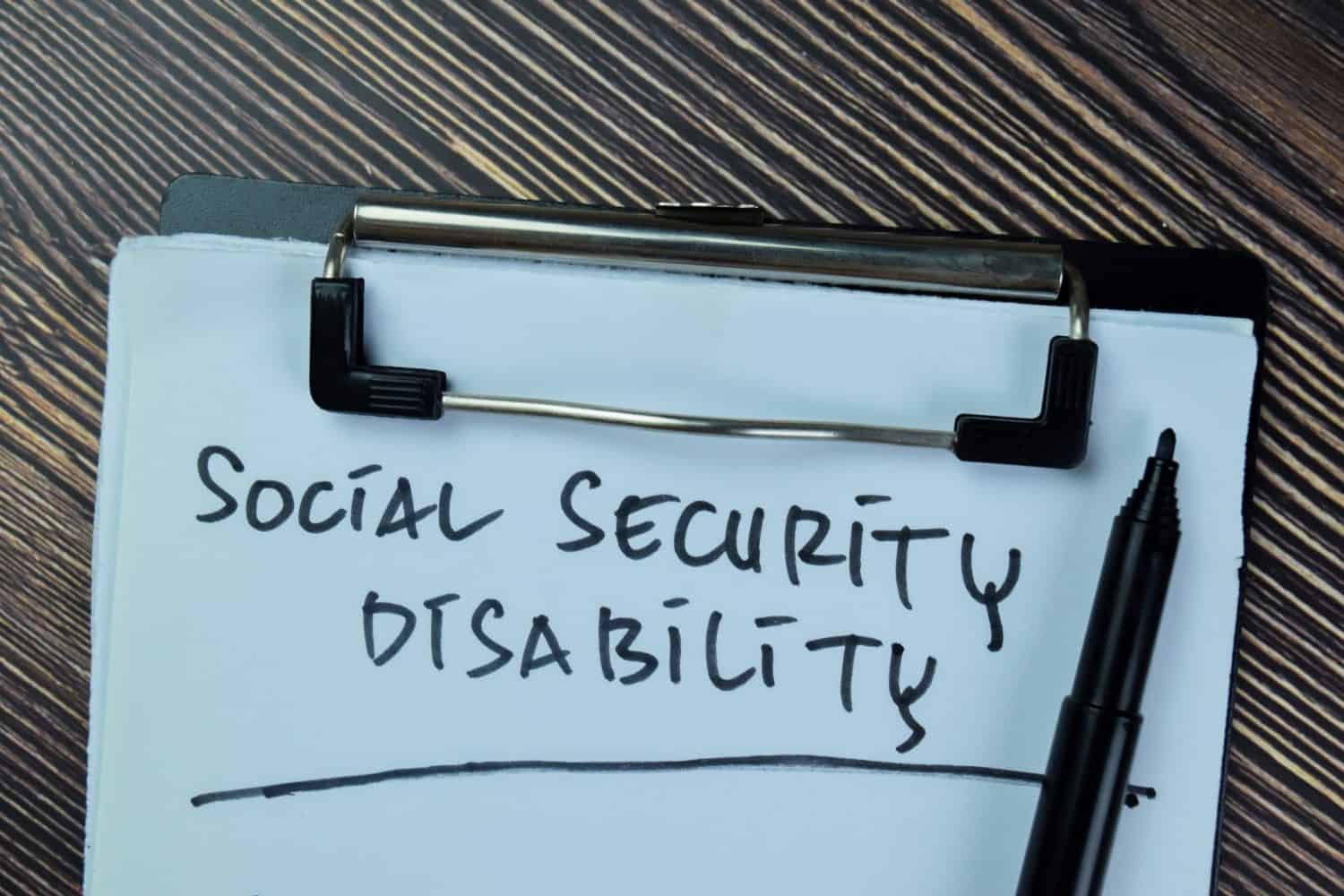 Concept of Social Security Disability write on paperwork isolated on Wooden Table. Selective focus on social security disability text