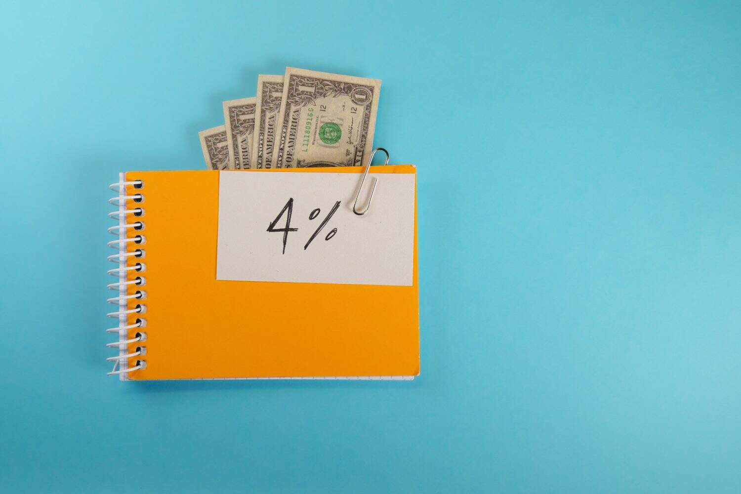 note in a sketchbook with the text 4%. 4 percent rule concept or total amount retiree should withdraw from retirement savings to establish steady safe income.