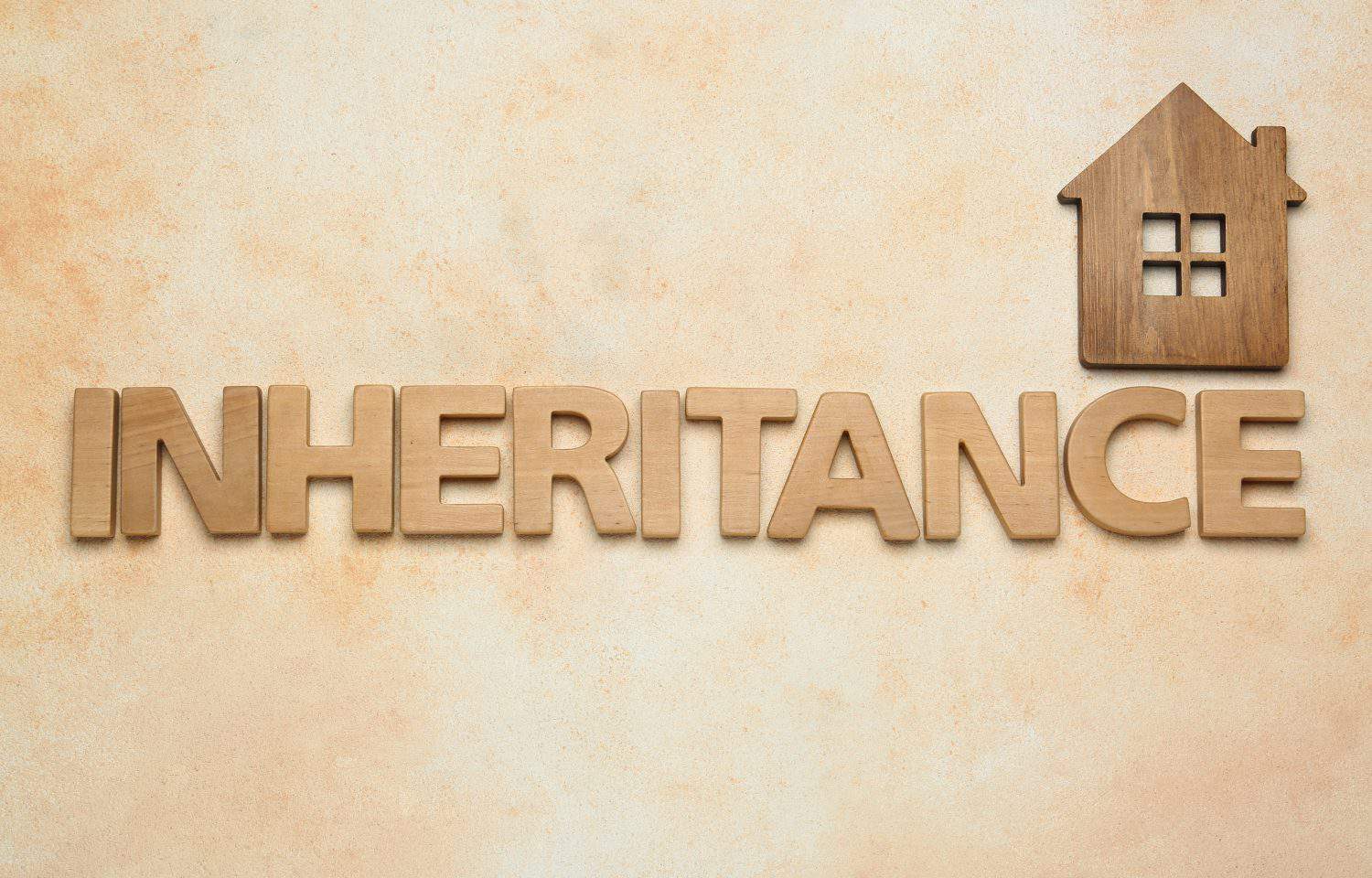 Word Inheritance made with wooden letters and house model on beige background, flat lay