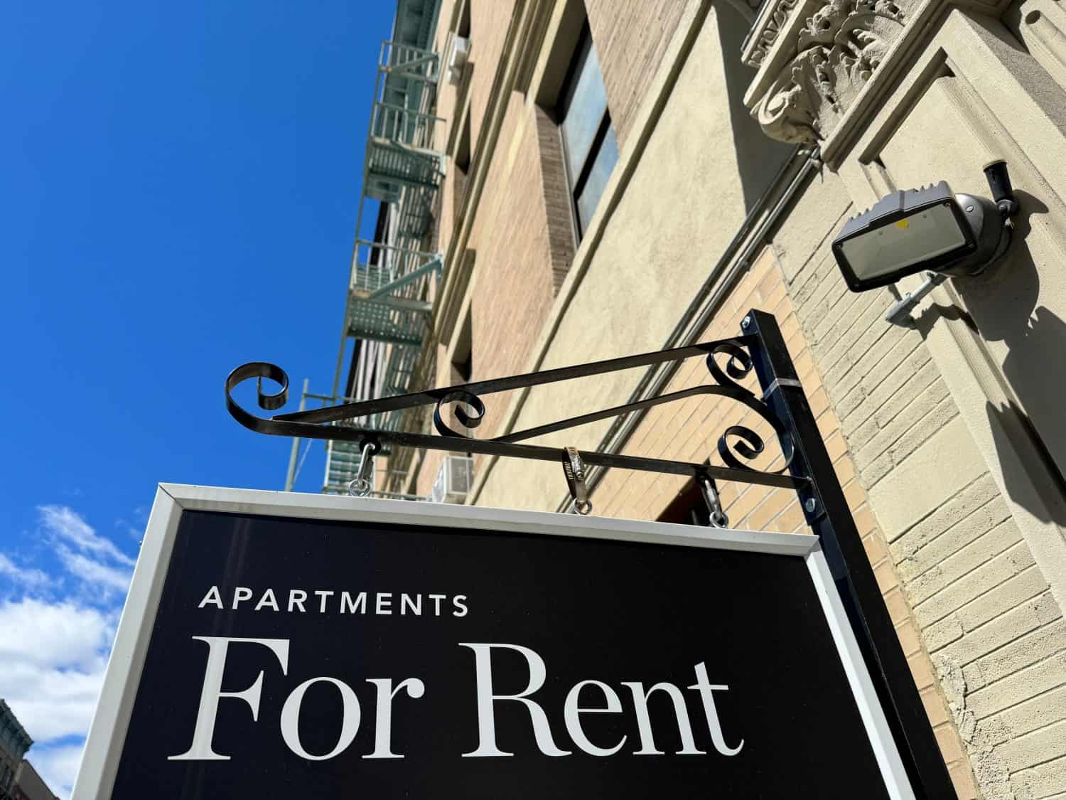 "Apartments for Rent" shingle hanging from a pre-war residential building in Harlem, Manhattan, New York City