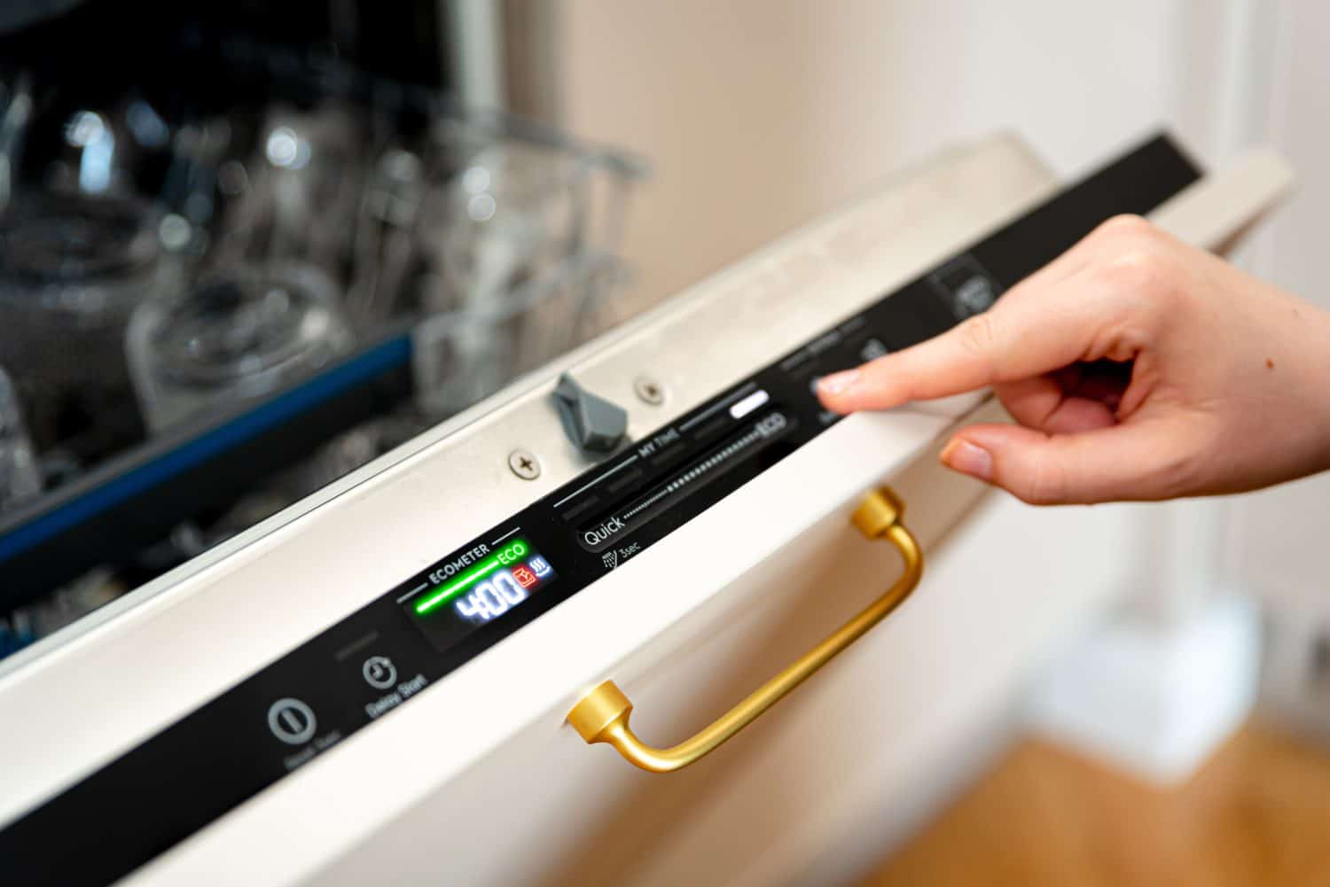 Woman choosing eco mode program on the digital control panel of the dishwasher. Eco cycle of dishwashing machine, energy saving at home concept