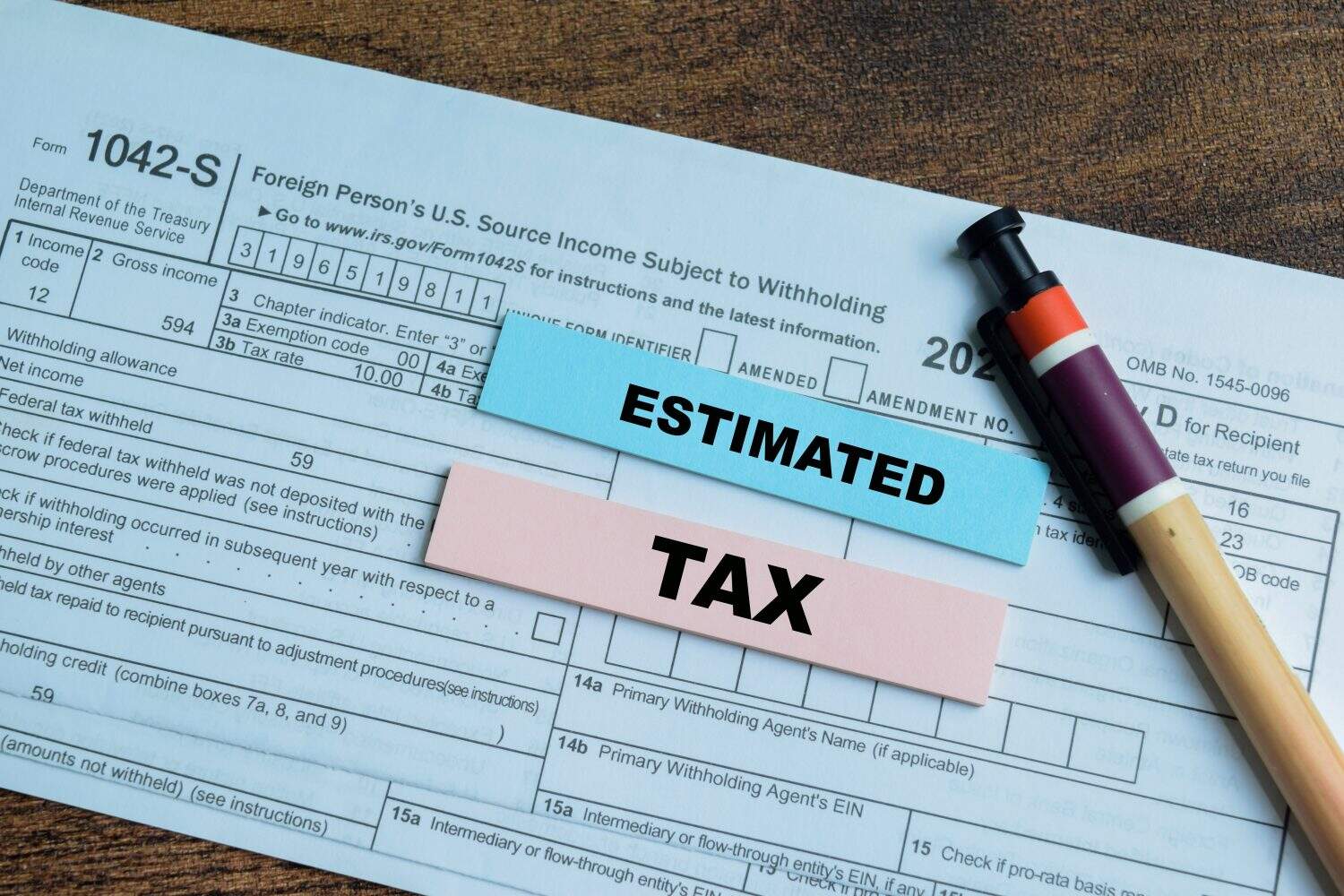 Concept of Estimated Tax write on sticky notes isolated on Wooden Table.