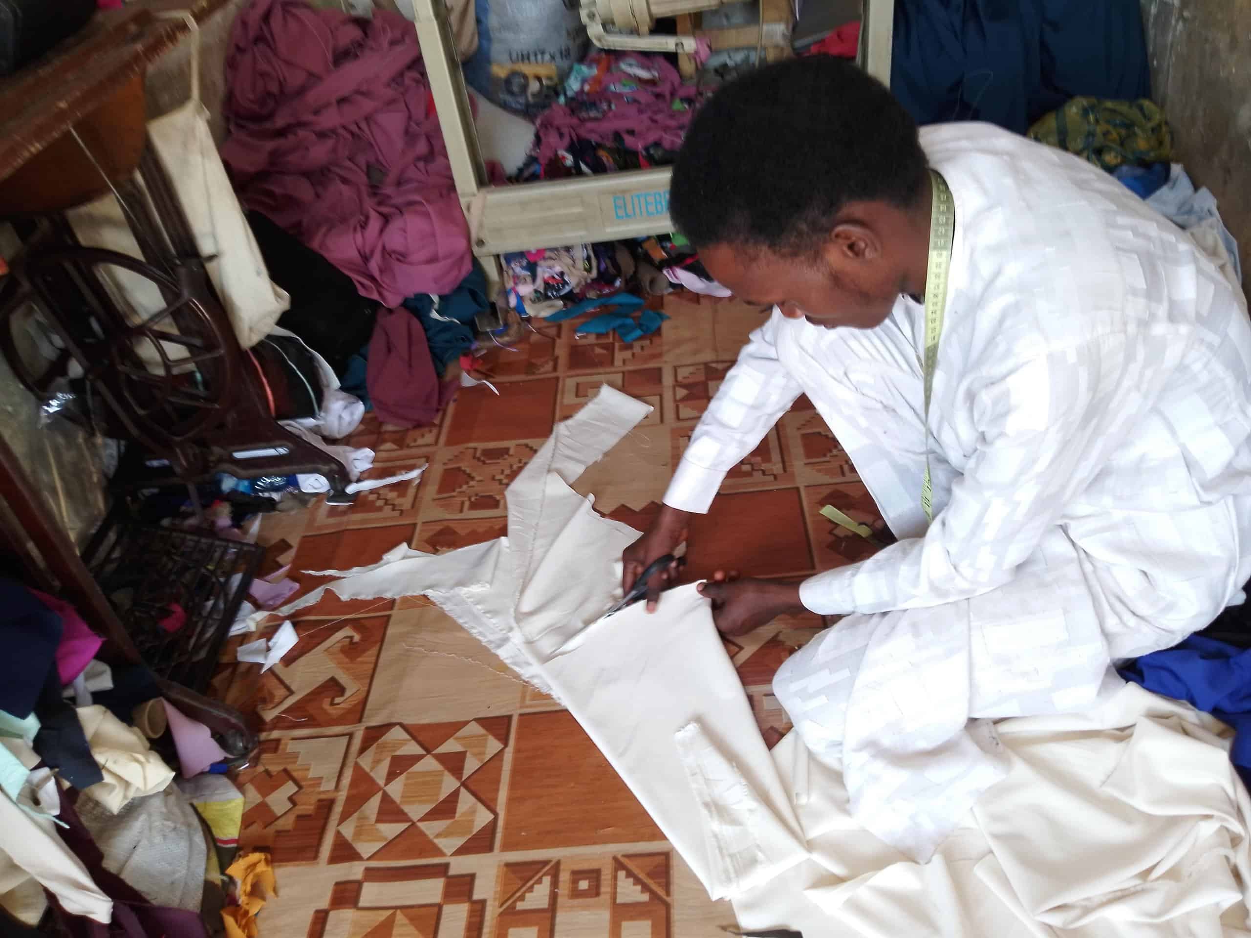 Tailor cutting clothes by Bembety