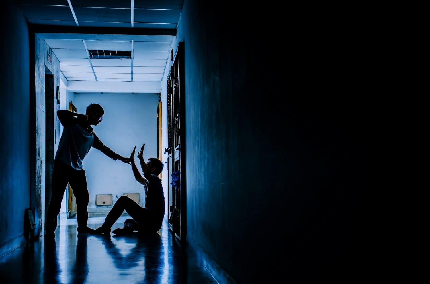 The silhouette of two young men conflict fighting with each other in the old condo