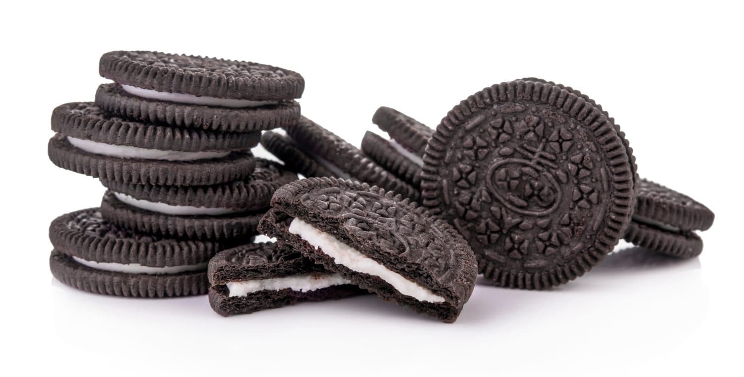 Chocolate cookies with cream filling tower isolated on white background.