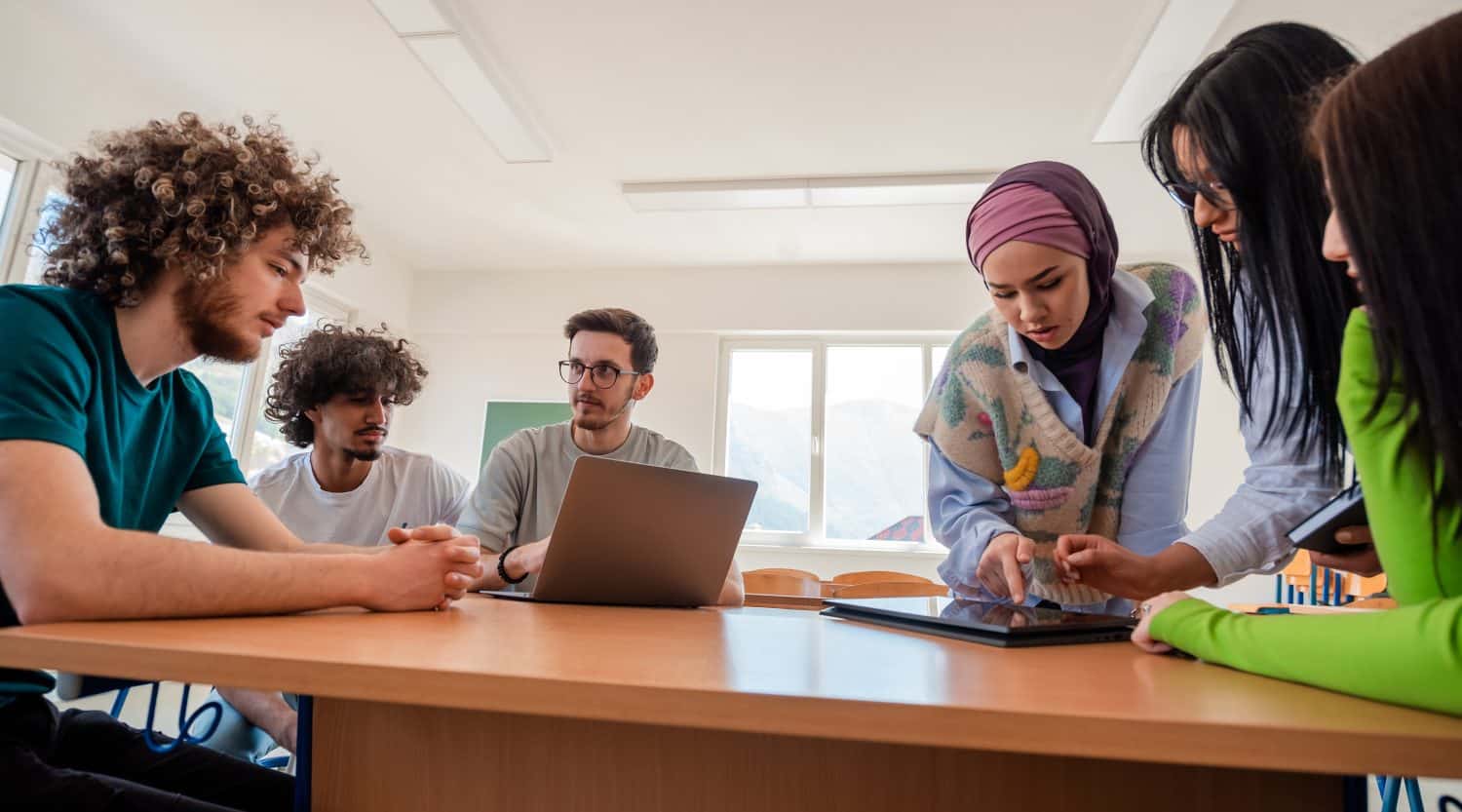 A group of diverse college students studying together or young business team working on a project plan.
