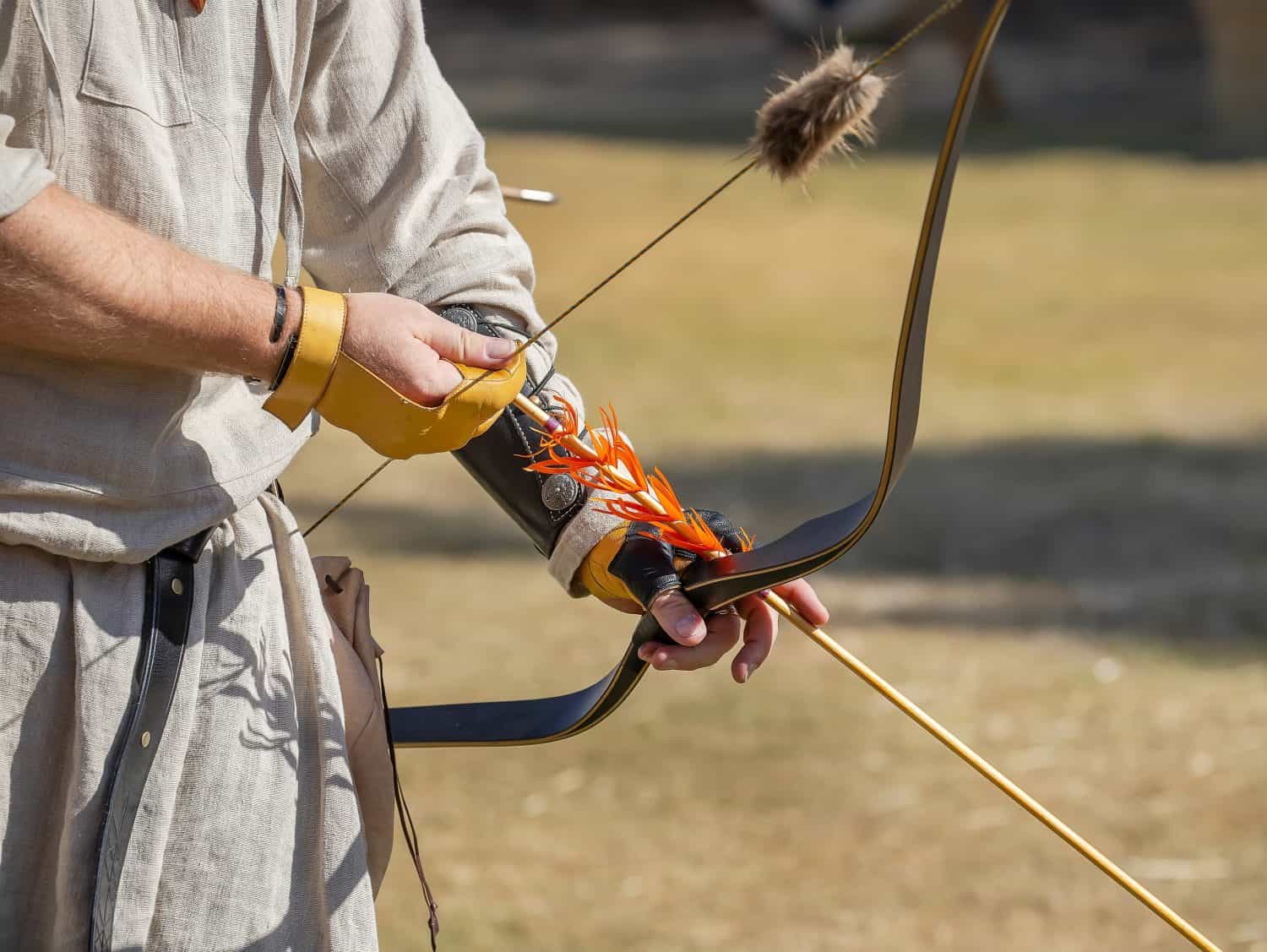Medieval archery equipment, bow and arrow in the hands of a man