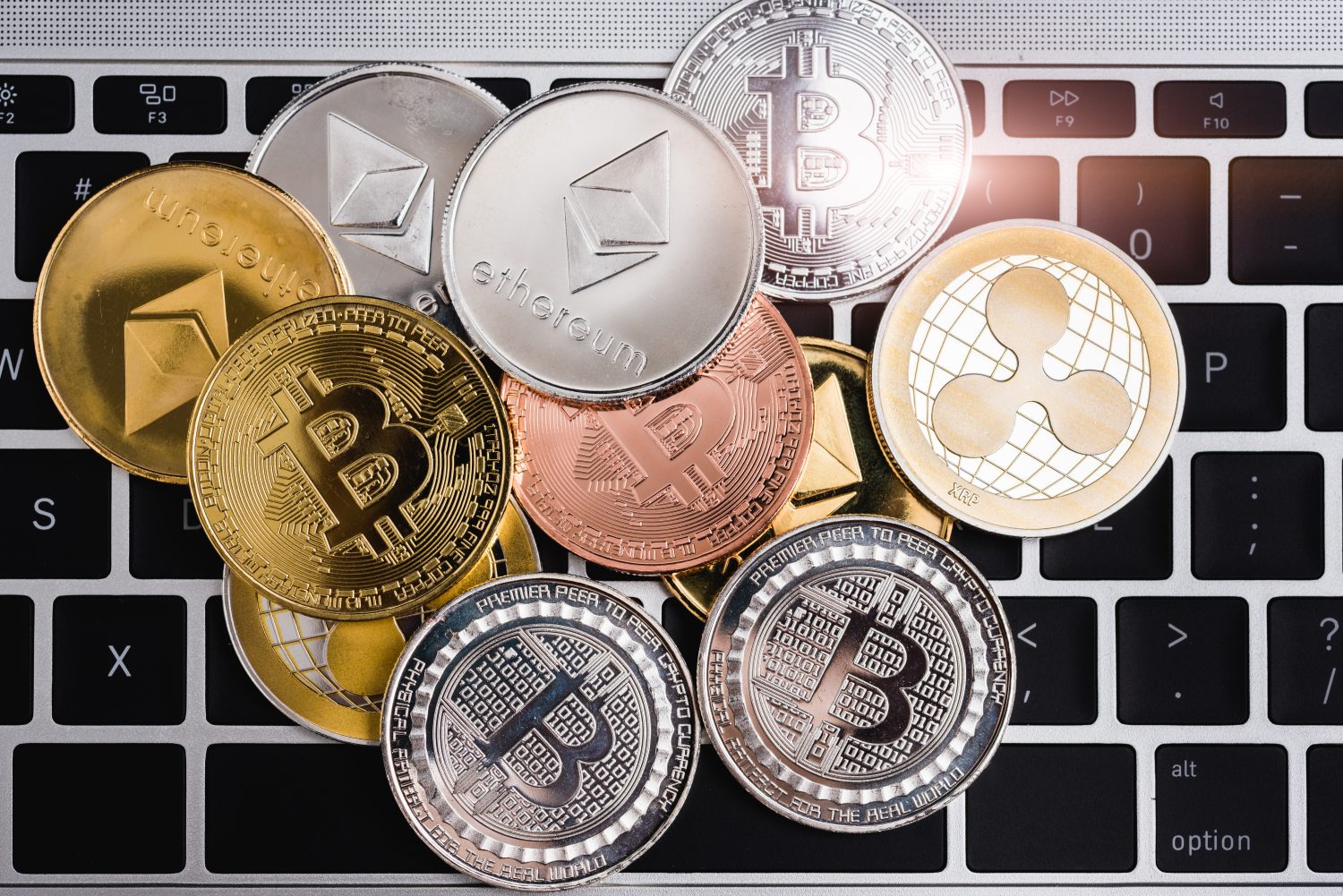 Virtual ripple XRP, Ethereum and Bitcoin coins currency finance money stack together on keyboard of laptop computer, cryptocurrency concept