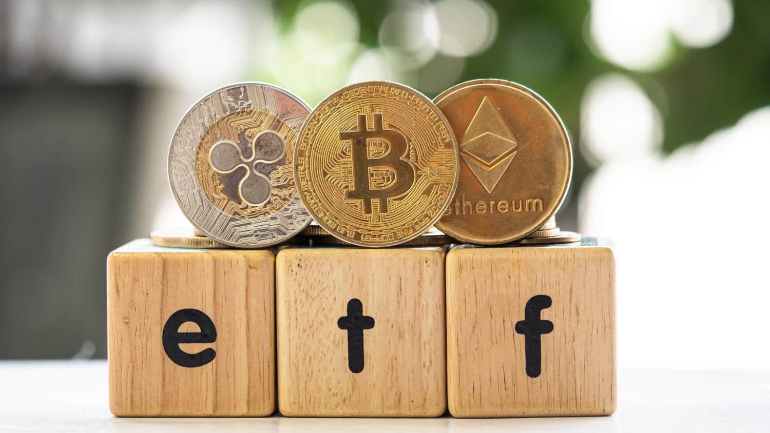 Bitcoin coin, XRP and ETH coin put on box wooden have text ETF on it , Concept Entering the Digital Money Fund.