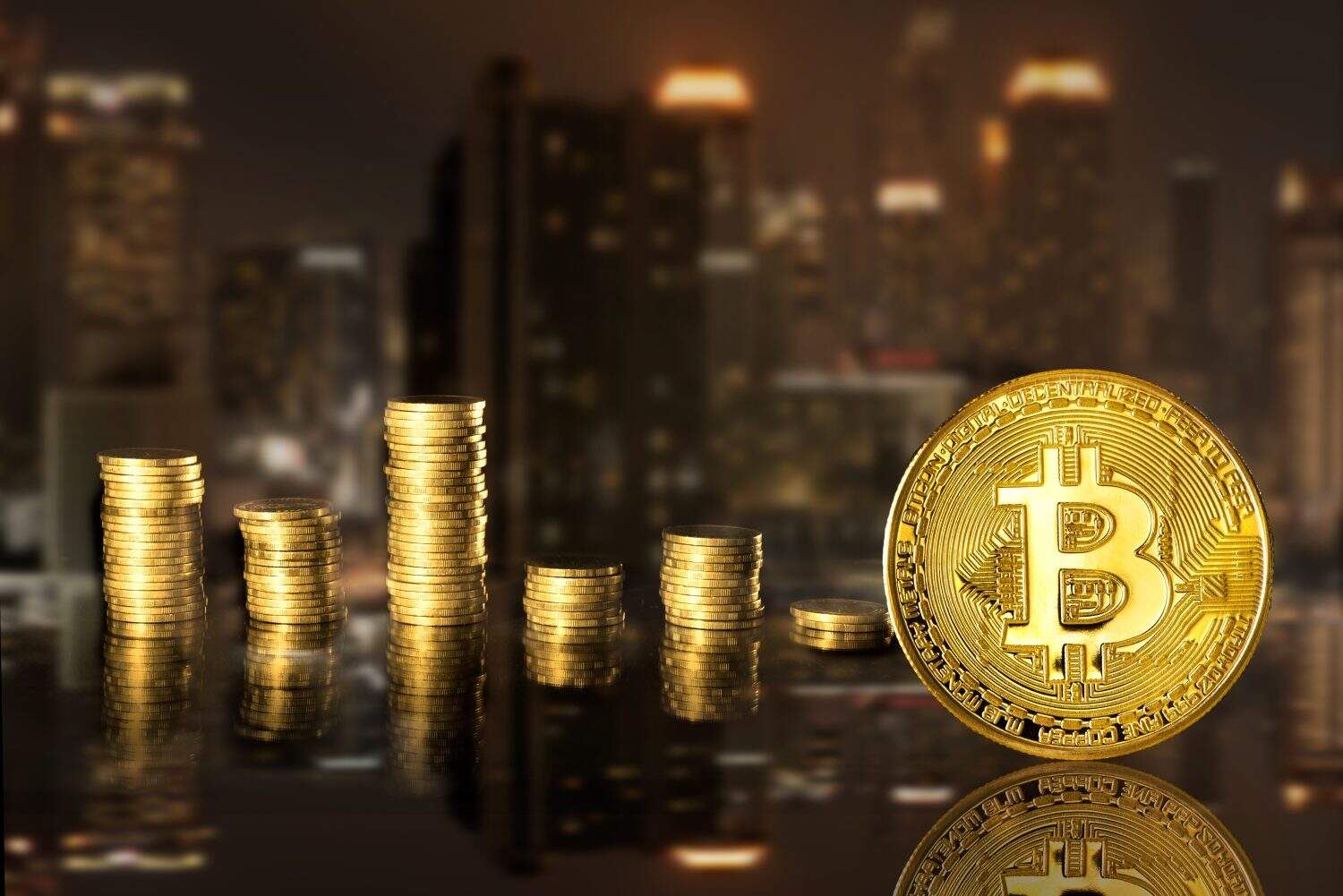 Bitcoin and stack coins of baht on the night city background. Finance and investment concept.