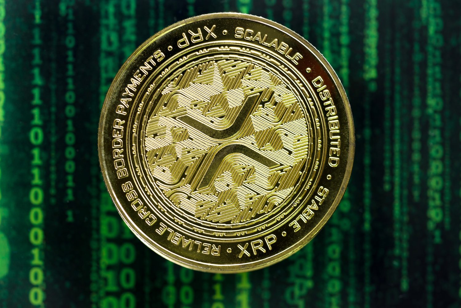 Cryptocurrency concept. A close up shot of Ripple XRP cryptocurrency coin in front of a green matrix screen. selective focus in the center.