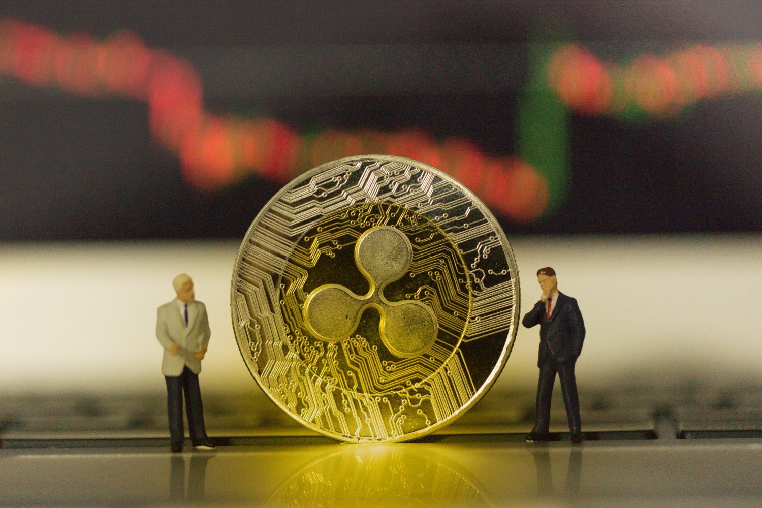Ripple(XRP) Coins and businessman's on technical chart background,ETH,BTC,XRP,LTC,EOS,BCH