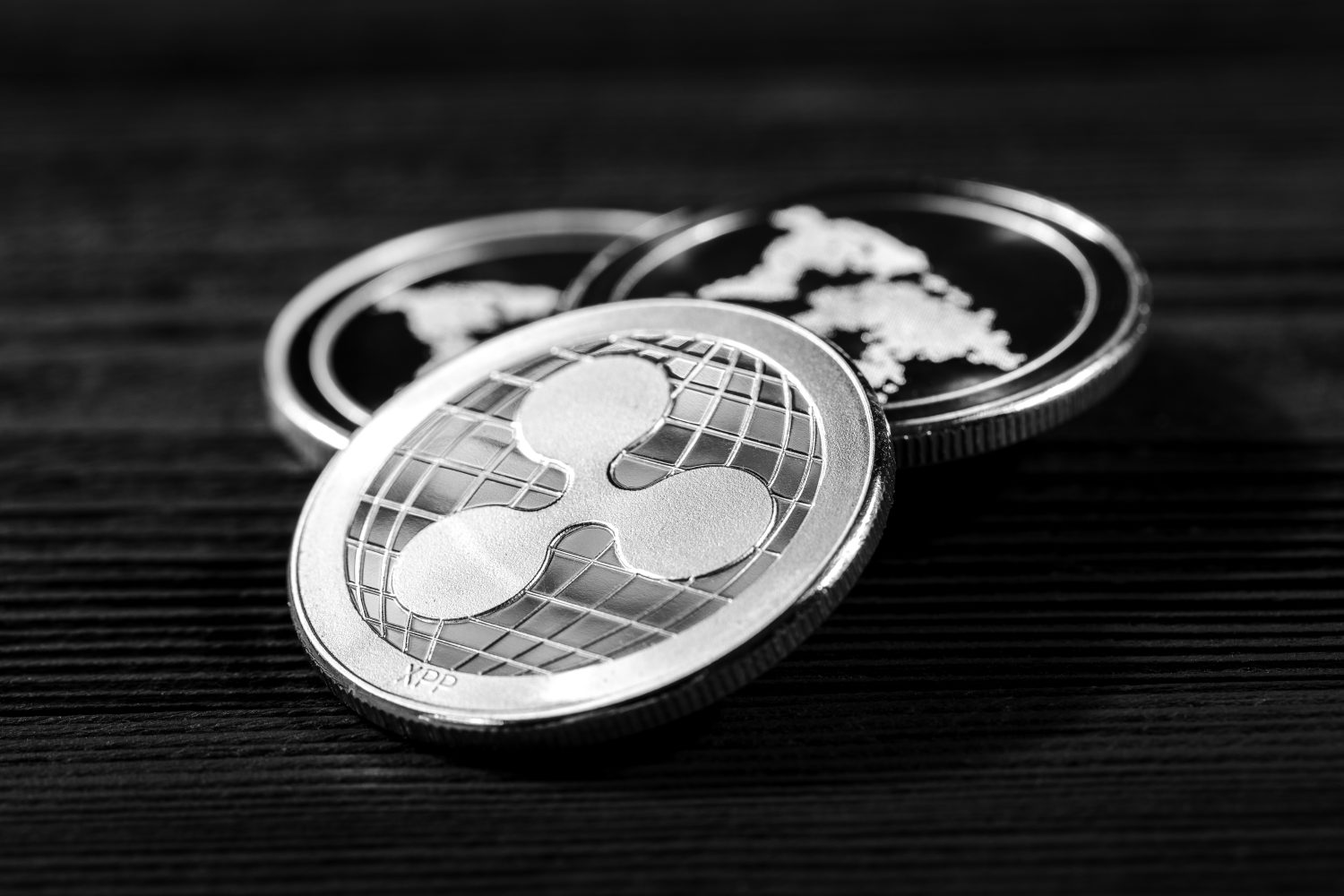 silver ripple coins on a black wood background