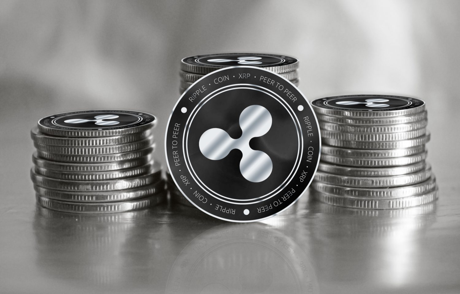 Ripple (XRP) digital crypto currency. Stack of black and silver coins. Cyber money.